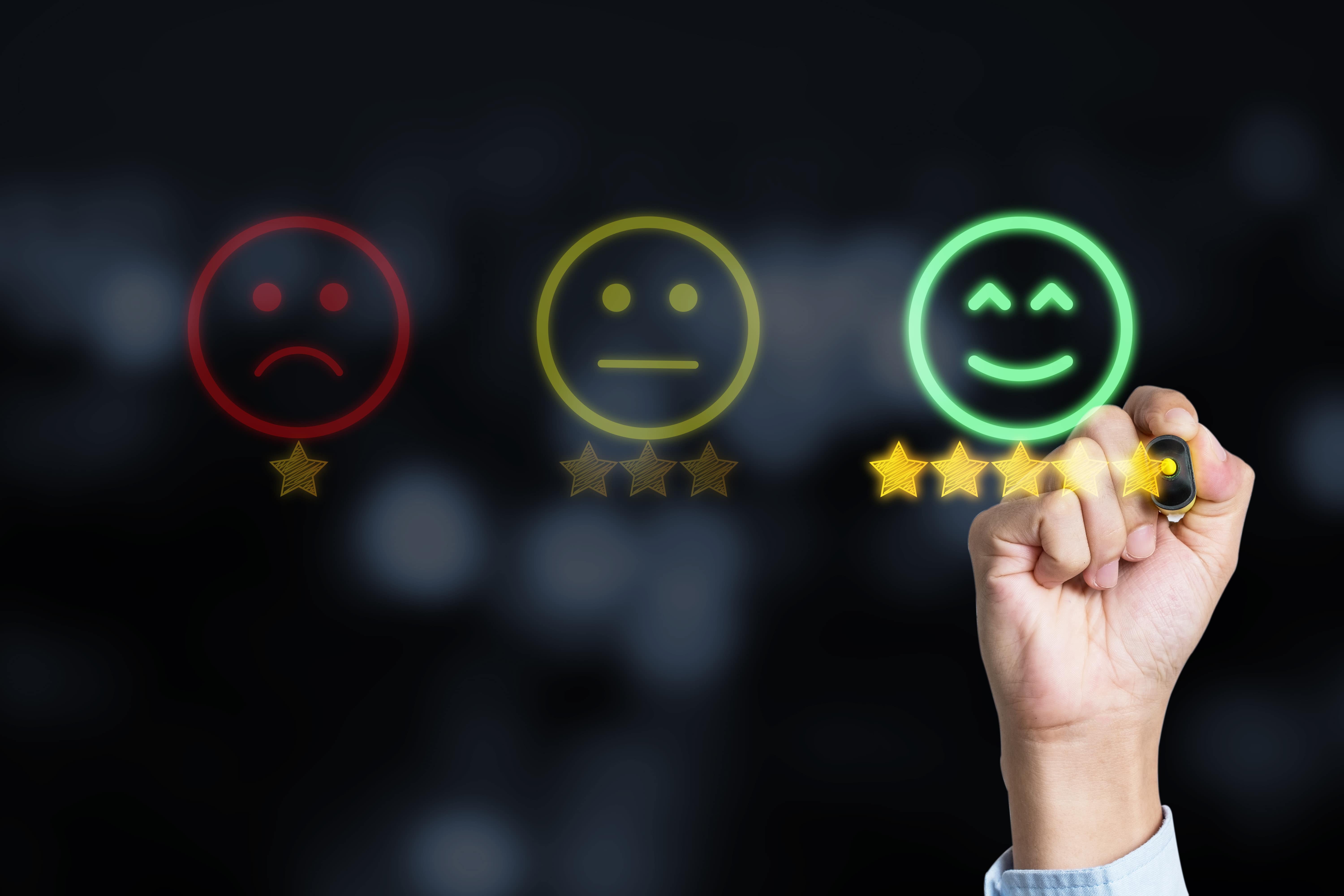 Kundenzufriedenheit steigern: Hand verleiht 5 Sterne für positive Bewertung auf dunklem Hintergrund.