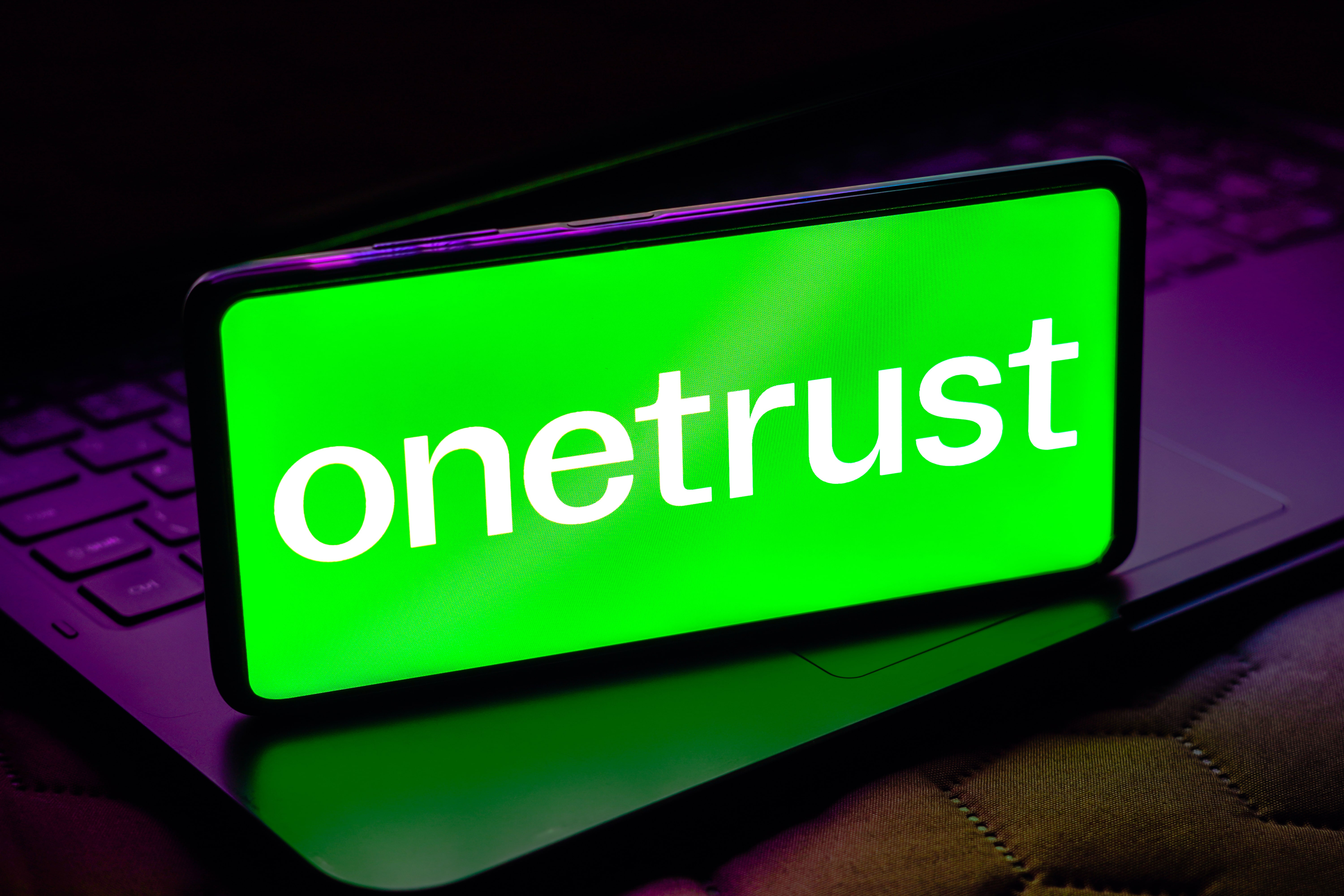 Grünes Smartphone-Display mit onetrust, Fokus auf Datenschutzsoftware auf der Webseite.