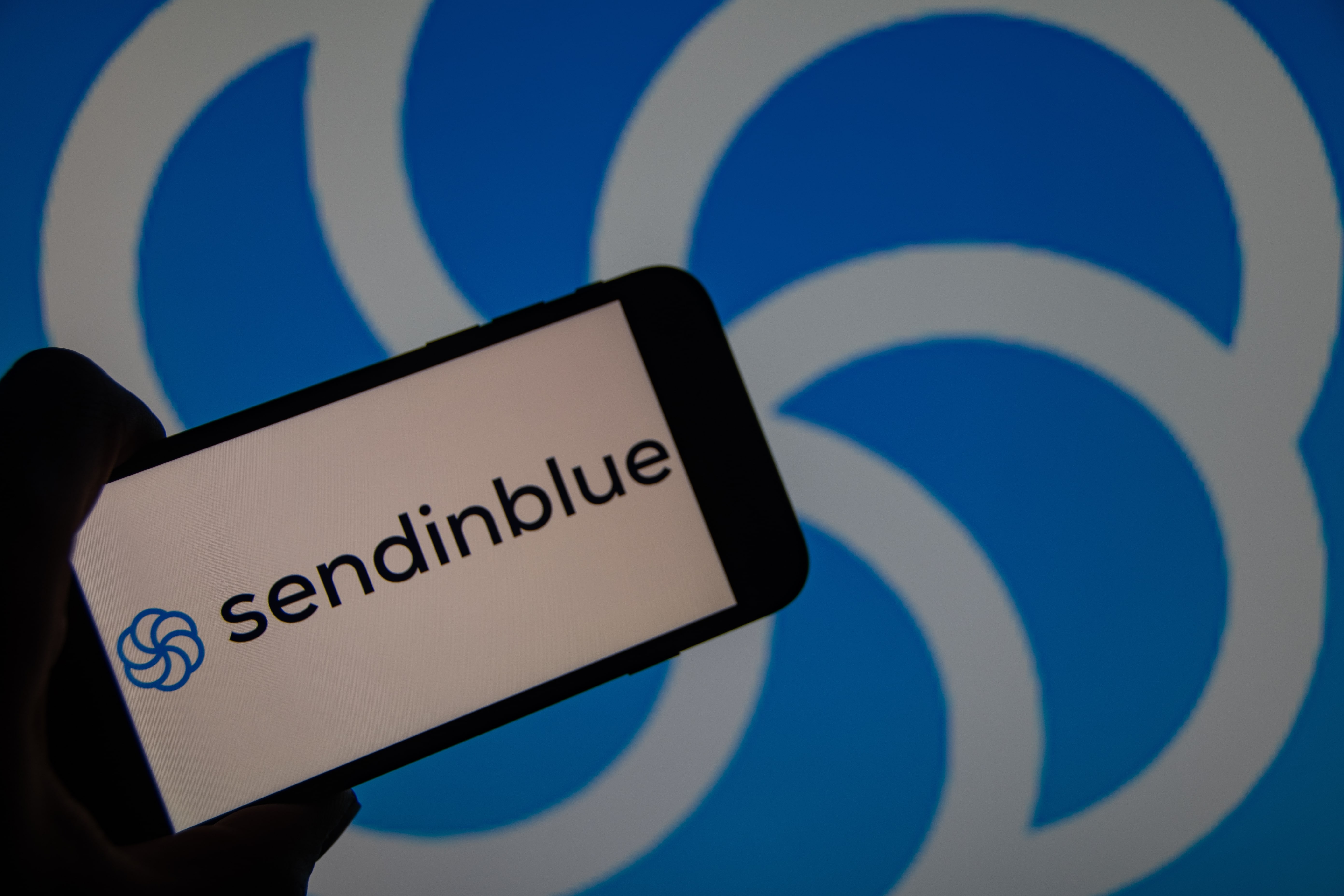 Smartphone zeigt Sendinblue-App, Fokus auf digitale Marketinglösungen in Blogbeitrag über effektive Kommunikationstools.